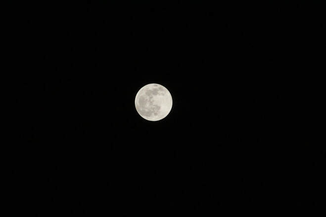 Photograph of full moon against black night sky